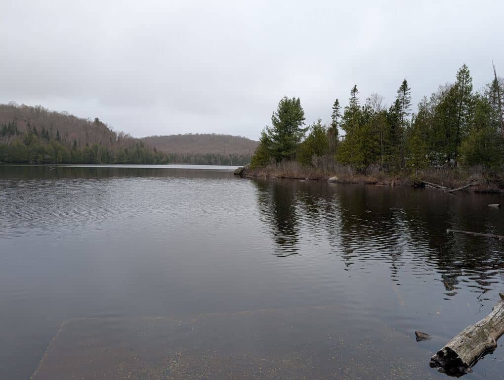 Overcast day on Grass Lake in Kearney Ontario with calm water and forested shoreline
