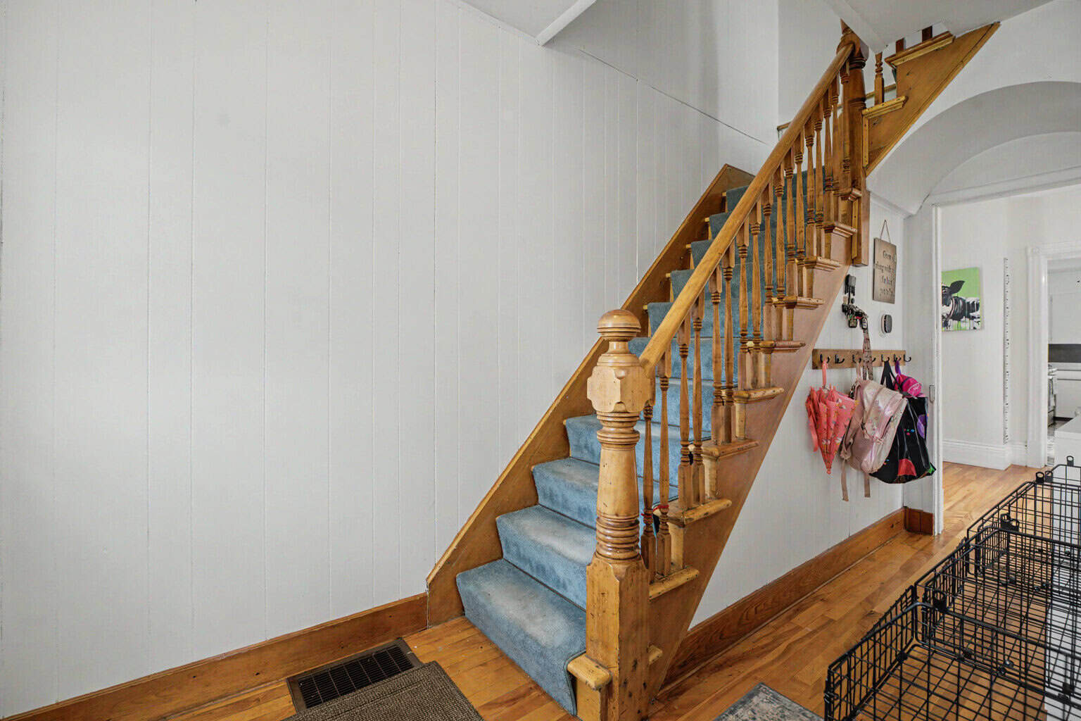 Front entrance hallway with original staircase and solid wood posts at 152 Main Street, Burk's Falls, Ontario